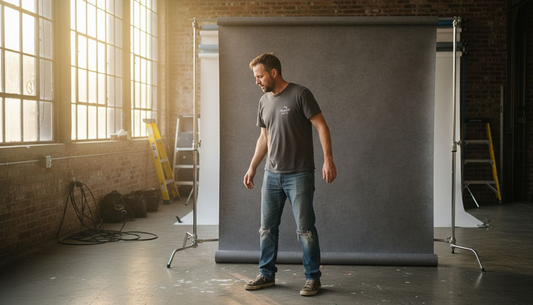 Photographer setting up vinyl backdrop in studio