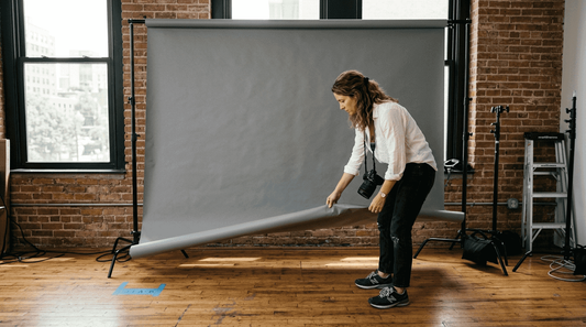 Photographer adjusting large backdrop in studio